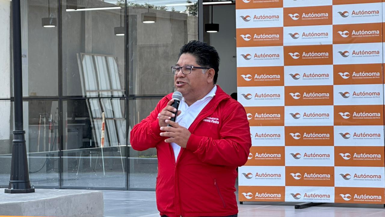 Discurso del alcalde Rennán Espinoza frente al banner de la Universidad Autónoma